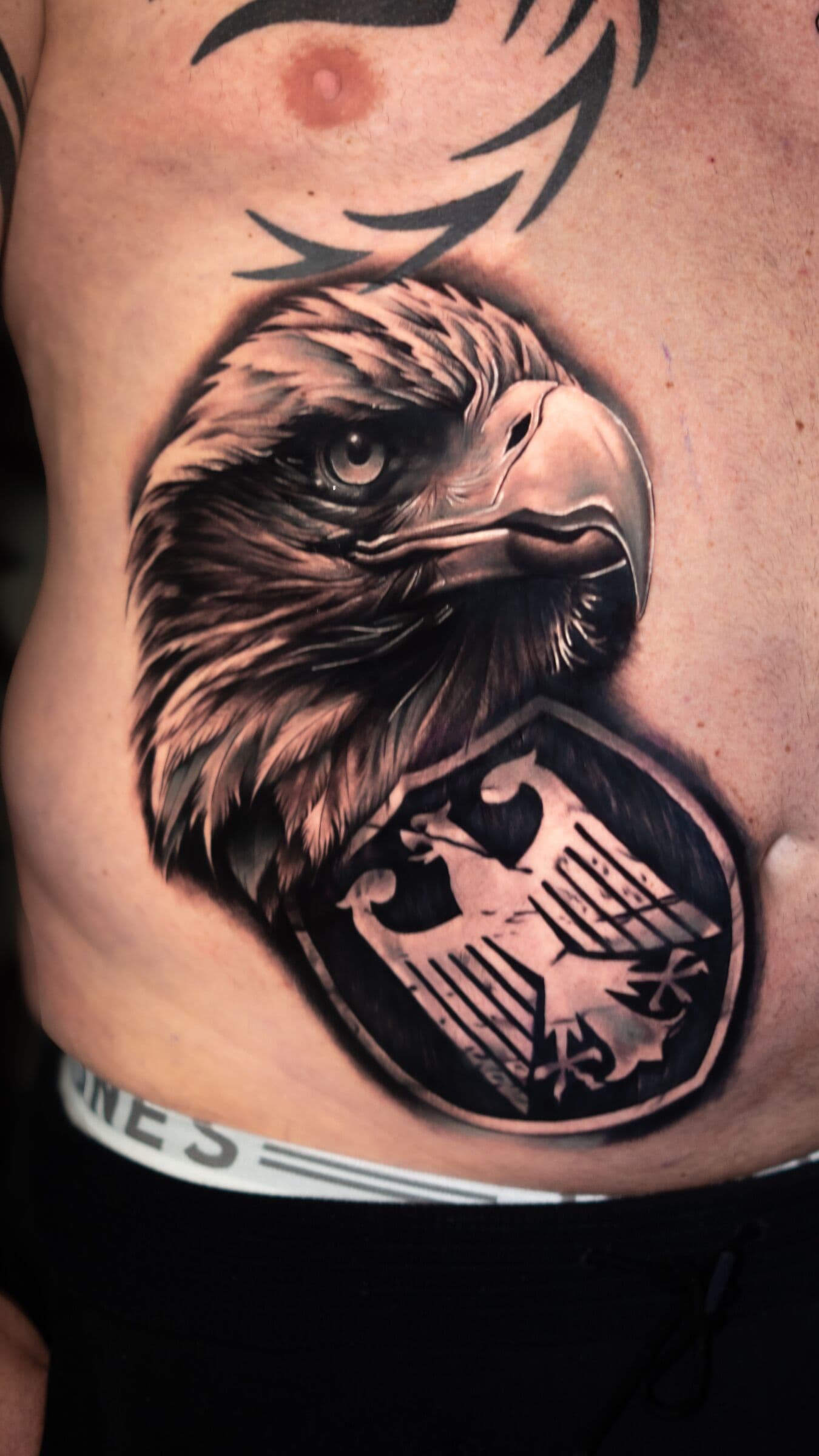 Adler mit Wappen, Tattoo an den Rippen