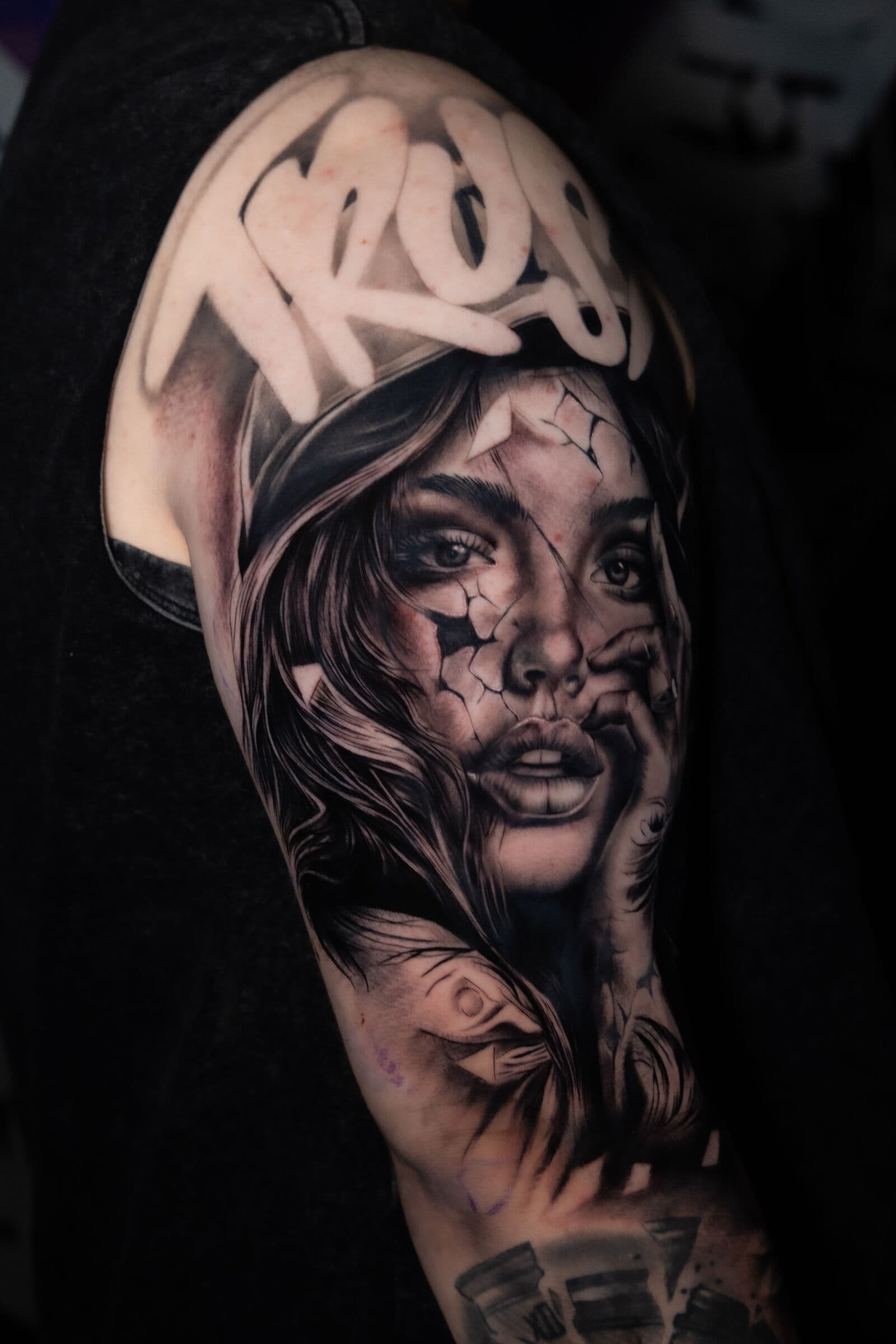 Frauenporträt mit Schriftzug, Tattoo am Oberarm